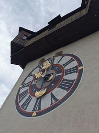 Low angle view of clock on building against sky