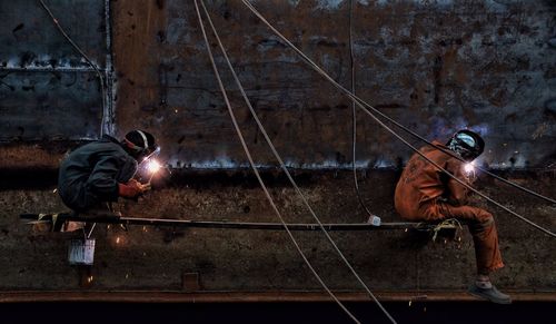 Full length of welders working