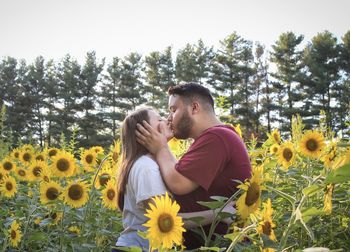 Young couple on yellow flowering plants