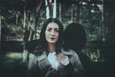 Portrait of woman standing against trees