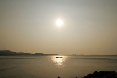 Scenic view of sea against bright sun