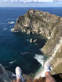 Low section of man on cliff against sea