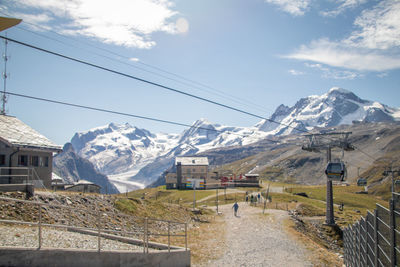 Houses by snowcapped mountains against sky