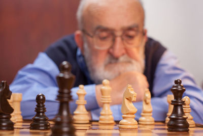 Close-up of senior man playing chess