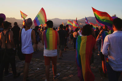 Rear view of people walking on footpath with flags