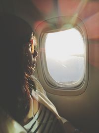 Woman looking through airplane window