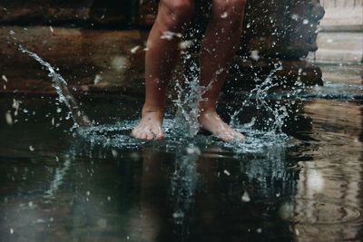 Low section of man splashing water