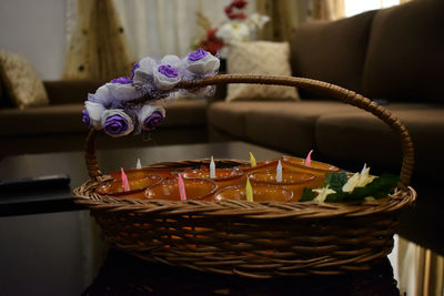 Close-up of candles in wicker basket on table