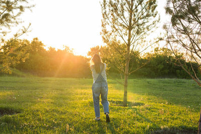 Rear view of man standing on field against sky