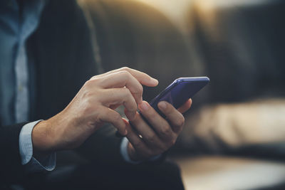 Midsection of man using mobile phone