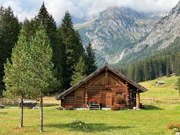 House on field by trees and mountains