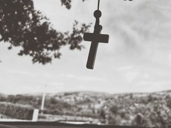 Low angle view of lighting equipment hanging against sky