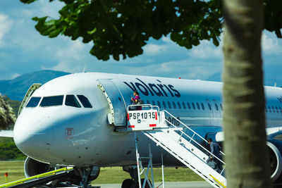 Airplane on airport runway against sky