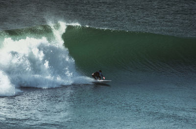 Man surfing on wave in sea