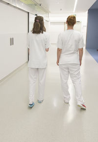 Rear view of people walking in corridor of building