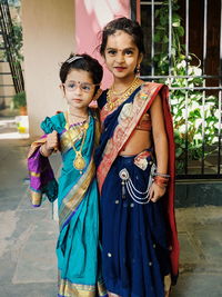 Portrait of cute girls in traditional clothes standing outdoors