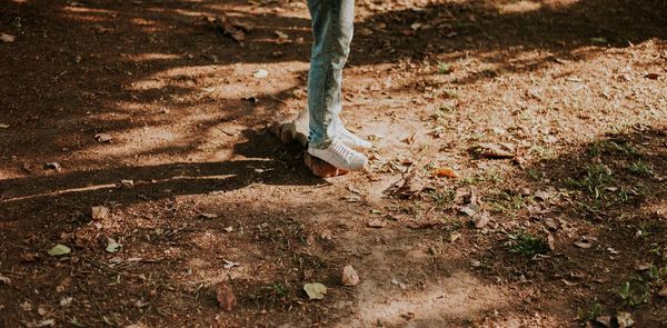 Low section of woman standing on field