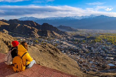 Women looking at view while sitting on mountain