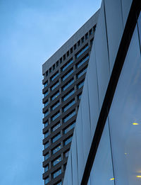 Low angle view of modern building against blue sky