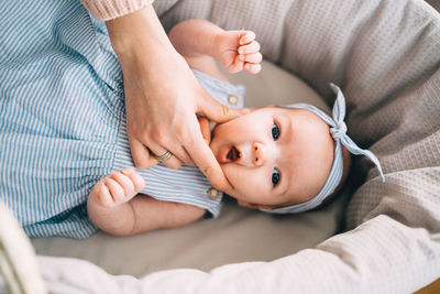 Cropped hand of woman touching baby girl