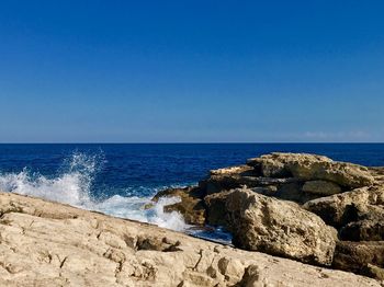 Scenic view of sea against clear blue sky