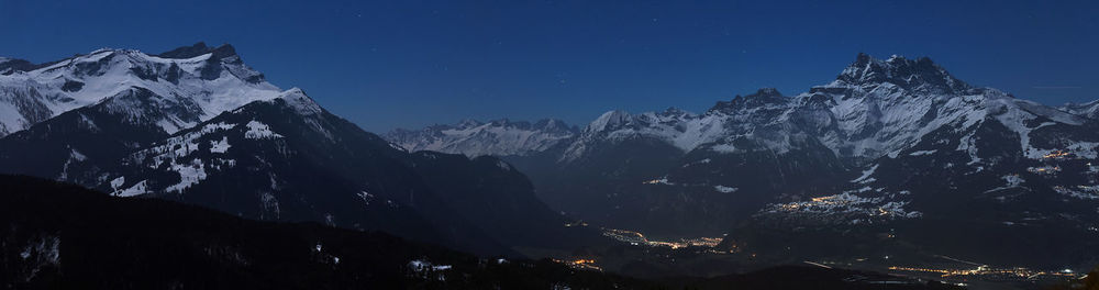 Scenic view of snowcapped mountains against sky at night