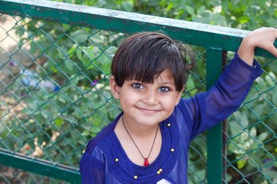 Portrait of smiling girl on fence