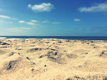 View of calm beach against blue sky