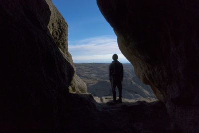 Rear view of man looking at rock formation