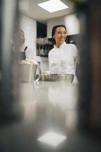 Portrait of young woman using mobile phone while sitting on table