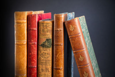 Close-up of books on shelf against black background