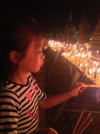 Rear view of girl standing at illuminated night