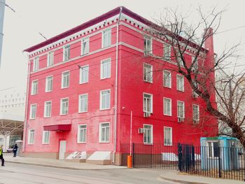 Building by street against sky in city