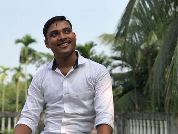 Portrait of smiling mid adult man standing against sky