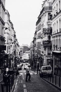 Man walking on street amidst buildings in city