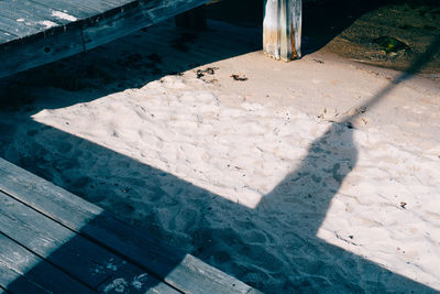 Low section of person standing by swimming pool