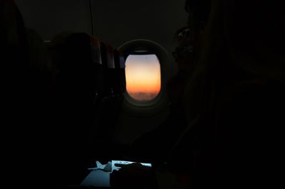 Silhouette man seen through airplane window