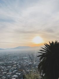 Scenic view of sea and buildings against sky during sunset