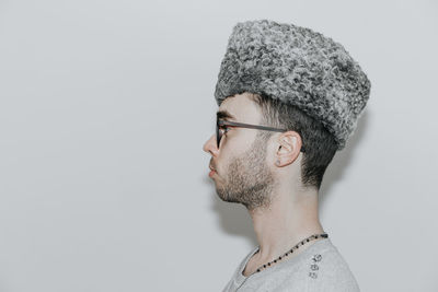 Side view of man wearing sunglasses and hat against white background