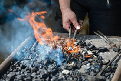 Midsection of man burning coal