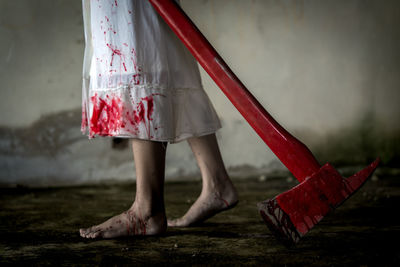 Low section of evil woman with axe walking in room