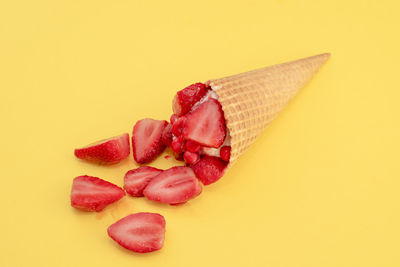 Close-up of strawberry cake against yellow background