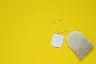 High angle view of heart shape on yellow paper