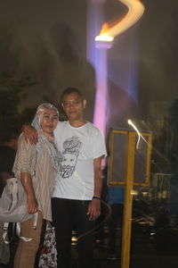 Man and woman standing at illuminated night