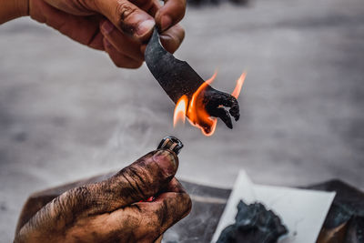 Cropped hand burning coal