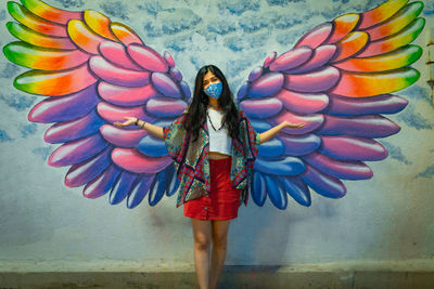 Midsection of woman standing against multi colored wall