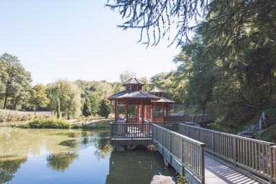 Footbridge over lake against sky