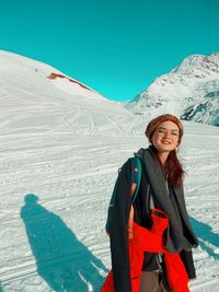 Full length of woman standing on snowcapped mountains during winter