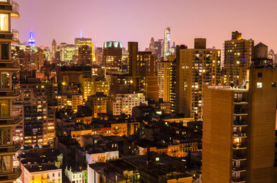 Illuminated cityscape against sky at night