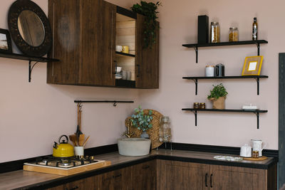 Interior design of the kitchen-dining room in a modern scandinavian style with dark wooden furniture